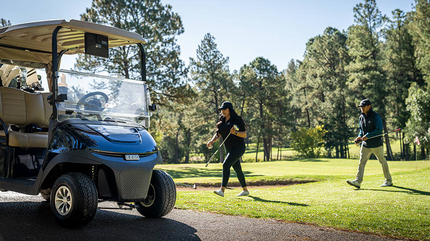 Golfers make their way back to their E-Z-GO golf cart.